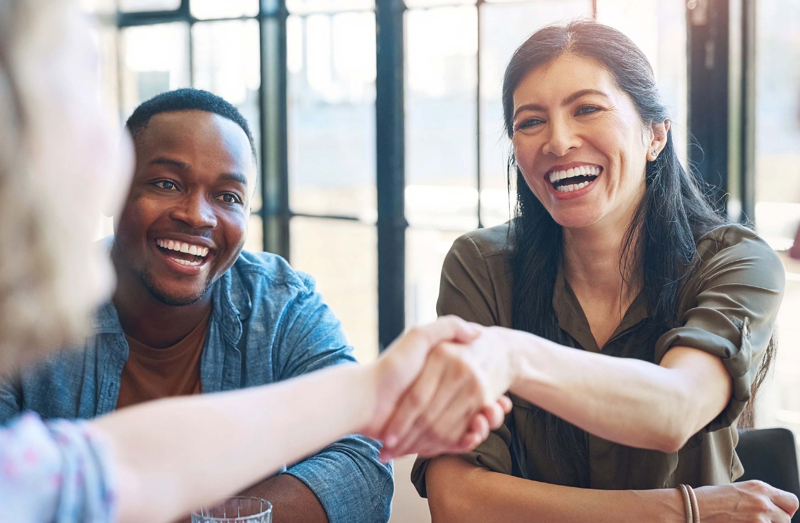 A group of colleagues laughing together during a collaborative meeting, reflecting the partnerships behind VASIS.
